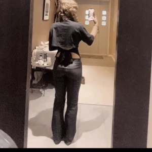 Svarta bootcut byxor från ONLY XS - Säljer ett par svarta bootcut-byxor från ONLY i storlek XS. Byxorna har låg midja och är i ett glansigt material som ger en snygg look. De sitter tight upptill och har utsvängda ben. Perfekta om du vill ha en trendig och edgy vibe.