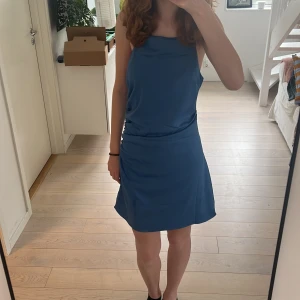 Blå klänning  - Super vacker blå sommarklänning från H&M med kors i ryggen och dragkedja. Har bara använt en gång och köpte den för 300 kr. Säljer på grund av att jag inte tycker om den.