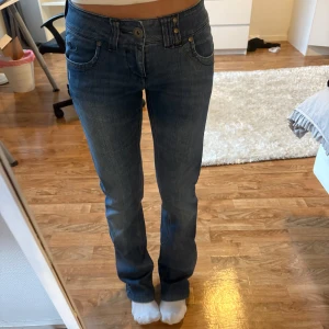 Blå bootcut jeans från ONLY - Snygga blå jeans från ONLY med bootcut-modell och klassisk femficksdesign. Jeansen har låg midja, raka ben med lätt utsvängning och detaljerade sömmar. Tillverkade i mjukt denimtyg med lite stretch för skön passform.