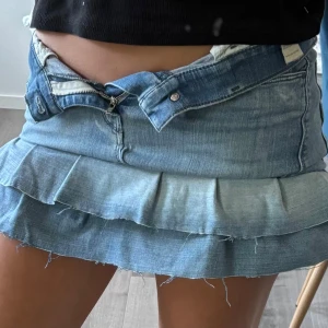 Blå jeanskjol med volang från Diesel - Supersnygg ljusblå jeanskjol från Diesel med volanger. Jag har gjort kjolen själv av ett par jeans från diesel! Kjolen har klassiska bakfickor och dragkedja fram. Storlek är ungefär S mer exakt w26. Den är använd 1 gång och är i bra skick. Hör av er vid extra frågor och priset är möjligen diskuterbart💕💕