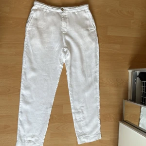 Vita linnebyxor från Zara - Snygga vita linnebyxor från Zara i storlek M men sitter mer som S Byxorna har rak passform, resår baktill i midjan och sidfickor. Perfekta för varma dagar med sin lätta och luftiga känsla. Klassisk look med knapp och dragkedja framtill.