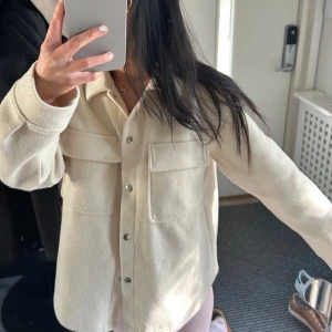 ModernSommarjacka i från Gina Tricot - Jättesnygg vaniljfärgad sommarjacka från Gina Tricot med stora bröstfickor och silvriga tryckknappar. Jackan har en rak passform, klassisk krage och är tillverkad i mjukt material. Perfekt färg nu under sommaren eller att matcha till höstoutfits! Pris kan diskuteras!❤️