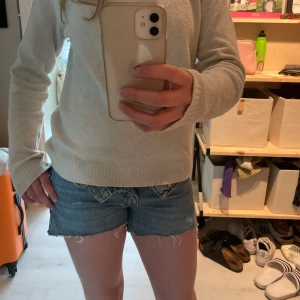 Lågmidjade jeansshorts  - Säljer ett par blå lågmidjade jeansshorts me snyggt slitna detaljer. De va jeansbtxor från början men klippte t shorts o fixa dom. D e för små som ni kan se men passar perfekt me att vika ner dom🤗Kontakta innan köp! Ny pris för jeansen var 500!