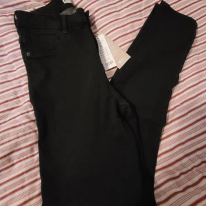 Svarta skinny jeans - Svarta skinny jeans med klassisk femficksdesign och smal passform. Snygga och enkla att matcha med allt, perfekta för dig som gillar en stilren look. Jeansen har normal midja och är tillverkade i stretchigt material för extra komfort.