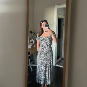 Svartvit långklänning & Other Stories - Supersöt långklänning från & Other Stories med svartvitt mönster. Sval och flowy passform med slits. Perfekt för sommardagar. Säljer då den inte kommer till användning längre.