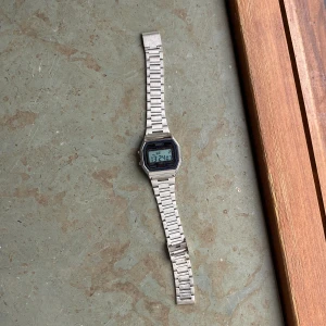 Digital klocka i silver från Skmei - Digital klocka från Skmei med klassisk retrostil. Klockan har en fyrkantig display, alarm, kronograf och vattenskydd upp till 30 meter. Armbandet är i silverfärgad metall och har en stilren, tidlös look som passar till det mesta. Original pris 500kr typ