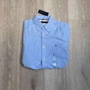 Helt ny Ljusblå skjorta från Tommy Hilfiger🤩 - Helt ny och oanvänd Skjorta som är riktigt snygg. Denna skjorta är ifrån Tommy Hilfiger och är i storlek S
