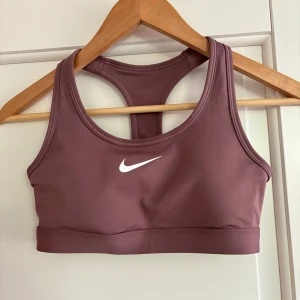 Nike sport-bh - En nike sport-bh i en lila nyans. Har använt några gånger, nypris 549kr. Köpte för liten storlek så därför säljer jag den igen!💕