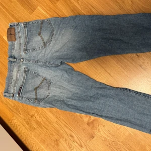 Ljusblå U.S. Polo jeans straight fit - Säljer ett par ljusblå jeans från U.S Polo med klassisk femficksdesign och snygga slitningar. Jeansen har raka ben och normal passform, perfekt för en avslappnad stil. Tidlös denim med läderpatch i midjan.
