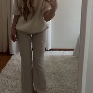 Beige kostymbyxor från Chelsea - Snygga beige kostymbyxor från Chelsea med klassisk passform och pressveck. Byxorna har mid waist, raka ben med lätt bootcut och hällor för bälte. Materialet känns mjukt och har en lätt stretch🌸Ordinarie pris 500kr, använda endast två gånger