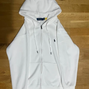 Polo zip - Vit polo zip helt ny kommer med ralph laures påse. Är i storlek M med lite korta armar så de passar S också. Vid snabb affär kan priset diskuteras (med snabb affär menar jag samma dag ni köper den)