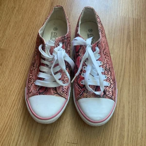 Rosa låga sneakers med ormmönster - Snygga platta skor med ormönster i storlek 39. Använt några få gånger i sommaren. Brukar ha dessa med mina shorts och någon sommartröja men säljer pga fått nya. 💕
