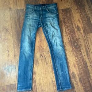Blå jeans från Tiger of Sweden - Snygga blå jeans från Tiger of Sweden med klassisk femficksdesign och orangea kontrastsömmar. Jeansen har en rak passform och normal midja, tillverkade i slitstarkt denim. Perfekta för dig som gillar en tidlös och stilren look.