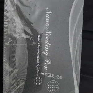 Nano Needling Pen Microneedle System - Nano Needling Pen är ett automatiskt microneedle-system för ansiktet. Perfekt för att boosta hudvårdsrutinen och ge huden extra glow. Pennan är svart och silver, och används för att stimulera huden med små nålar.