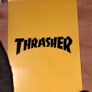 Thrasher affisch  - Tuff gul Thrasher-affisch – perfekt för dig som älskar skatekultur och vill addera attityd till rummet! Klassisk Thrasher-logga i starka färger som verkligen poppar på väggen. Passar utmärkt i sovrummet, vardagsrummet eller i skatehörnan. Redo att ramas in eller hängas upp direkt!