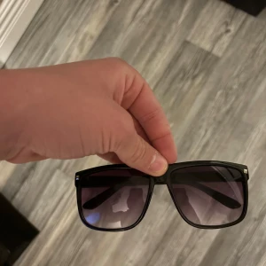 Raybans boyfriend liknande - Stilrena solglasögon med svart, bred båge och fyrkantig form. Glasen är mörka med en lätt toning som ger en cool vibe. Perfekta för att lyfta din look under soliga dagar. Helt nya