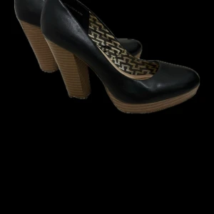 Svarta pumps med träklack - Snygga svarta pumps med hög, bred träklack och rund tå. Insidan har ett mönstrat foder i beige och svart. Perfekta för dig som vill ha både stil och komfort.