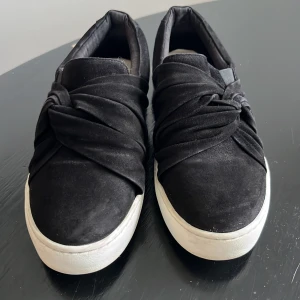 Svarta sneakers från Pace med twistad detalj - Svarta sköna sneakers från Pace med twistad detalj över foten. Storlek 36. Skorna har vit platt sula och passar till allt.