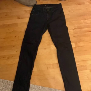 Svarta jeans från Tiger of Sweden - Säljer ett par svarta jeans från Tiger of Sweden. Klassisk femficksmodell med knapp och dragkedja i gylfen. Snygg och stilren design som passar till det mesta. Perfekta för dig som gillar en tidlös look.