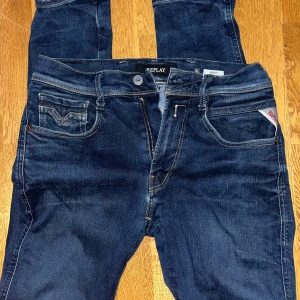 Replay Anbass Hyperflex - Säljer ett par mörkblå Replay Anbass jeans med klassisk femficksdesign och snygga detaljer. Jeansen har normal passform och dragkedja i gylfen. Perfekta för dig som gillar stilrena och bekväma jeans.