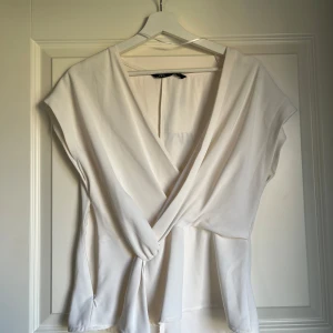 Vit topp - Vit omlottopp från Zara. Helt oanvänd, prislapp kvar. Storlek M🤗