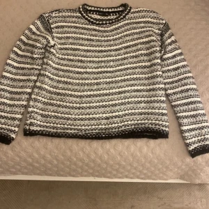 Randig stickad tröja från PrettyLittleThing - Säljer en svartvit stickad tröja från PrettyLittleThing i storlek S. Tröjan har ett randigt mönster och är långärmad med rund halsringning. Perfekt för kyligare dagar och enkel att matcha med olika outfits.