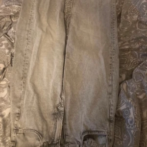 Grå  jeans - Säljer ett par grå tvättade jeansbyxor med raka ben och bakfickor. Klassisk femficksmodell och normal passform. Perfekta till vardags för en avslappnad stil.