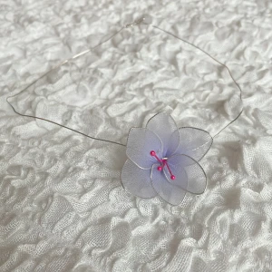 Halsband  - Unikt handgjort halsband med en stor, ljuslila blomma i organza och tunna silverfärgade trådar. Blomman har rosa detaljer i mitten som ger ett lekfullt intryck. Perfekt för dig som vill sticka ut med en söt accessoar.