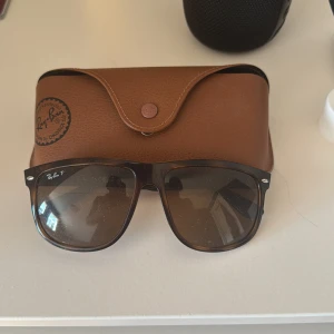 Bruna solglasögon från Ray-Ban boyfriend - Snygga solglasögon från Ray-Ban med bruna bågar och bruna glas. Klassisk modell med Ray-Ban-logga på linsen. Kommer med ett brunt fodral i läderlook.