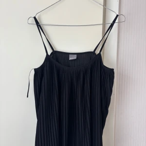 Svart plisserat linne från Gina Tricot - Säljer en svart plisserad topp från Gina Tricot i storlek 34. Klänningen har tunna axelband och ett luftigt fall. Jag bär vanligtvis storlek S/M. Tveka inte på att höra av vid frågor eller prisförslag!