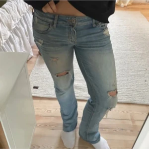 ljusblå jeans med slitningar  - Snygga och unika lågmidjade jeans med slitningar på knäna och låren. hon jag köpte dem av har sytt ut de med en liten kil på sidorna men ingenting som syns. De är bootcut/ straight med låg midja. Super snygga passar allt. lägger ut dem då dem tyvärr var för stor i midjan för mig. hör av er vid frågor. (LÅNADE BILDER!!!)