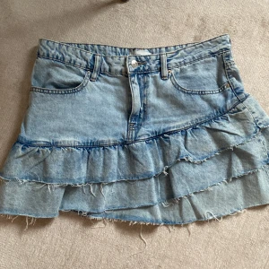 Jeans kjol med volangerr - Säljer denna super snygga jeanskjol från Gina Tricot som är slutsåld köpt för 600 och nästan aldrig använd 