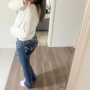 Miss me jeans  - Säljer ett par mörkblå Miss Me jeans med bootcut passform. Jeansen har snygga dekorationer och paljetter på bakfickorna samt tydliga kontrastsömmar. Klassisk femficksmodell och låg midja. Perfekta för dig som gillar detaljer!