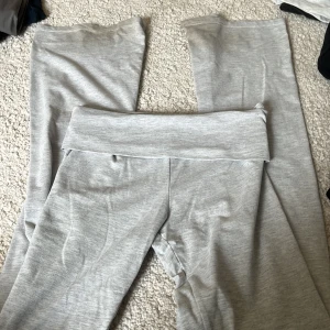 Grå mjukisbyxor från Nelly - Grå mjukisbyxor från Nelly med bred resår i midjan. Byxorna har en enkel och stilren design i mjukt material, perfekta för en avslappnad look. Modellen är rak och bekväm.