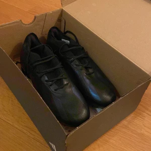  Adidas Crazyfast nightstrike elite | FG - Säljer ett par svarta fotbollsskor från Adidas. Skorna har snörning och en platt sula med dobbar för bra grepp på planen. Perfekta för dig som vill ha stilrena och funktionella skor till fotbollen. Säljer pga av att dom var för små när jag fick hem dom och hann tyvärr inte lämna tillbaka dom, Skorna är i ett perfekt skick och dobarna är som nya! Om ni har några funderingar så är det bara att skriva till mig!