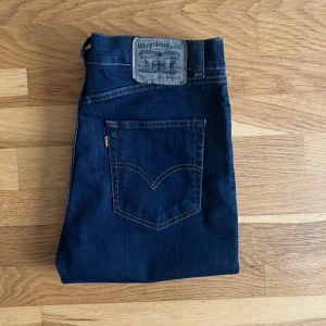 Levi’s 655 mörkblå jeans-slim fit/stretch strl W34/L34 - Levi's 655 är en mörkblå slim fit / stretch jeanmodell. Byxorna följer kroppens form med raka ben och passformen extremt bekväm och anpassningsbar. - 100% Bomull - Förslutning : Knappgylf