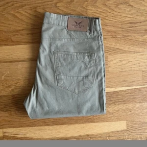  Kazary Jeans gul/khaki-slim fit strl W33L34 - Ett par stilrena khakifärgade byxor från Kazary Jeans. Byxorna har slim-fit design med en aning stretch för att ge ultimat komfort och sömlöslandning av funktionalitet och still. - 98% Bomull 2% Elastan - Slim - fit ( stretch blandning ) - Förslutning : dold drag kedjegylf Helt ny