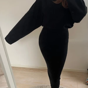 Svart långärmad tight klänning - Säljer en svart långärmad klänning med tight passform och rund hals. Klänningen är enkel och stilren, perfekt för dig som gillar minimalistisk stil. Materialet känns mjukt och följsamt mot kroppen.