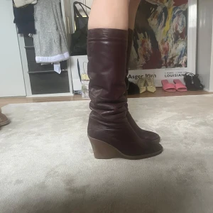 Bruna stövlar  - Säljer ett par bruna knähöga stövlar i skinn med snygg kilklack och rund tå.