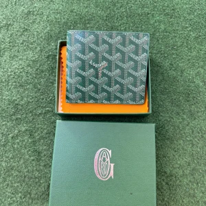 Grön plånbok  - Säljer en snygg grön plånbok  med deras klassiska mönster. Plånboken har flera kortfack och ett större fack för sedlar. Perfekt för dig som vill ha en stilren och exklusiv accessoar.