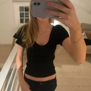 Svart tight topp med v-ringning - En svart, tight topp med korta ärmar och djup v-ringning. Har för mig att den är från Vila! Lånade bilder💓