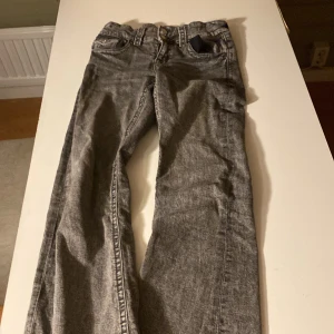 Grå jeans från Gina Tricot, stl 158 - Snygga grå jeans från Gina Tricot i storlek 158. Jeansen har utsvängda  ben, klassiska fickor och dubbla knappar framtill. Är öppen för bud!