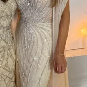 Champagnefärgad glittrig långklänning - Säljer nu min exklusiva klänning som har ett litet släp, storlek 34-36, klänningen är endast använd en gång. Klänningen finns att hämta från Västerås/ Örebro och kan även fraktas. Pris på klänningen är 4500kr