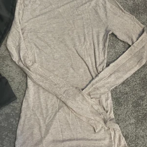 Beige långärmad tröja i bomull - En basic beige långärmad tröja i mjukt och tunt bomullsmaterial. Tröjan har en enkel  design med rund hals och normal passform.