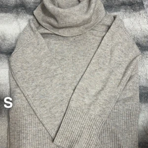 Beige polotröja i stickad ull - Mysig beige polotröja i stickad ull med ribbade muddar och hög krage. Perfekt för lager på lager och chill höst- och vinterstil. Enkel att matcha med jeans eller kjol för en clean look.🌸En fläck och lite noppor som lätt blir på dessa. Slitsar på sidorna. Storlek s men rymlig. 