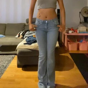 Ljusblå bootcut jeans från 157 - Snygga ljusblå jeans från 157 med klassisk femficksdesign och bootcut-ben. Jeansen har låg midja och är tillverkade i mjukt denimtyg som sitter skönt. Perfekta för dig som gillar en retro vibe och vill ha ett par jeans som sticker ut. Som referens: Jag är 166 cm lång och jeansen sitter perfekt i både midja och längd. Pris kan diskuteras!!!