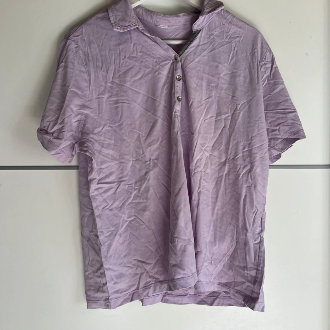 Ljuslila pikétröja med knappar