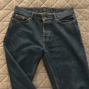 Blå jeans från Montén, rak modell - Klassiska blå jeans från Montén i rak passform. Jeansen har fem fickor, snygga kontrastsömmar och en läderpatch bak i midjan. Tillverkade i slitstarkt denimtyg som ger en tidlös look. Perfekta för dig som gillar enkel och clean stil.
