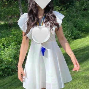 Vit kortklänning med volangärmar - Säljer en söt vit kortklänning med volangärmar och rund halsringning. Klänningen har en lätt utställd kjol och är perfekt för sommarens tillfällen. Materialet känns lätt och luftigt. Endast använd 2 ggr, sytt till den vid bysten så att den har en lite tajtare passform 