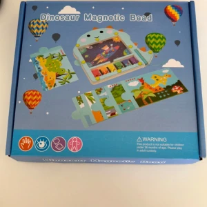 Dinosaur Magnetic Bead - En färgglad och lekfull magnetisk aktivitetsbok med dinosaurietema. Innehåller magnetiska kulor och pusselbitar som stimulerar kreativitet och finmotorik. Perfekt för unga som gillar pyssel och dinosaurier.